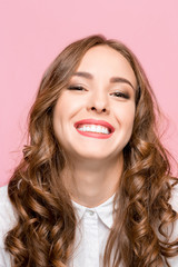 The young woman's portrait with happy emotions on pink background