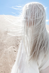 The girl with white hair among the sand mountains