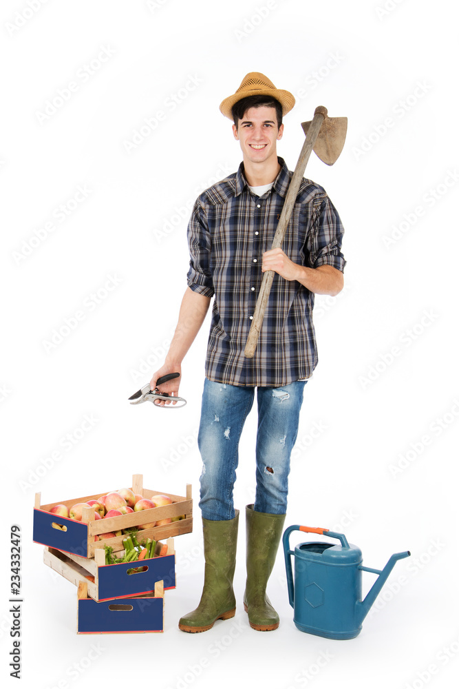 Young farmer with shears in his hand and hoe on his shoulder, at his ...