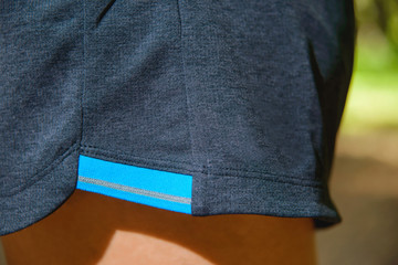 Wall Mural - shorts with a reflective stripe and a T-shirt. A man wearing a blue t-shirt and gray shorts. Sportswear for running. Lightweight in special sportswear.