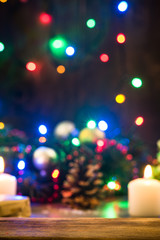 Wall Mural - Christmas background. Wooden board over blurred holiday lights and decorated table