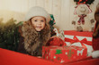 happy child girl with a Christmas present on wooden background