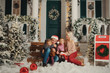 Holiday family couple on the Christmas porch of their house . Sitting outdoor with little child girl. Happy people kissing and hugging