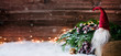 © emmi - Weihnachtswichtel sitzt auf einem Holzbrett in winterlichter Dekoration und wartet auf Weihnachten - Banner, Header, Headline - Format