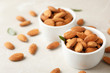 Tasty organic almond nuts in bowls on table. Space for text