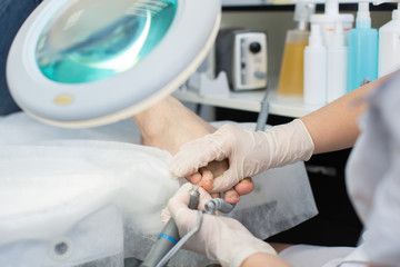 Podiatry procedure with pedicure machine. Care of the feet