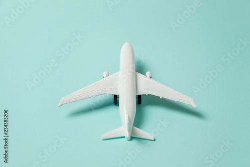 Fényképezés Simply flat lay design miniature toy model plane on blue pastel colorful paper trendy background
