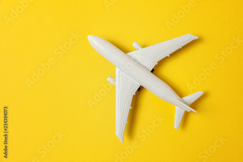 Fényképezés Simply flat lay design miniature toy model plane on yellow colorful paper trendy background