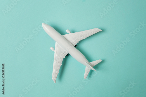Fényképezés Simply flat lay design miniature toy model plane on blue pastel colorful paper trendy background