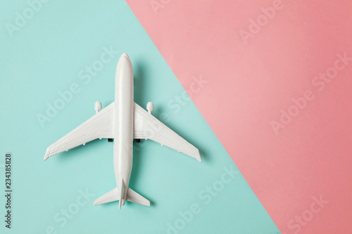 Fényképezés Simply flat lay design miniature toy model plane on blue and pink pastel colorful paper trendy geometric background