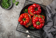 Red Bell Peppers Stuffed With Meat, Rice And Vegetables On Cast Iron Pan