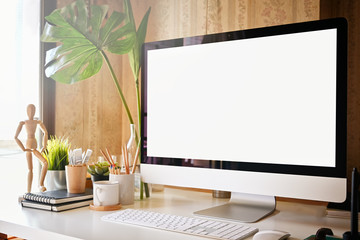 Mockup computer with white screen on office table. Workspace and blank screen computer.