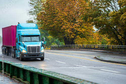 Big Rig Day Cab Semi Truck Transporting Container On Flat Bed Semi