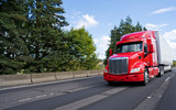 Fototapeta Mapy - Bright modern long haul big rig semi truck with semi trailer moving on the green road