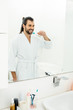 © LIGHTFIELD STUDIOS - handsome adult man brushing teeth in bathroom