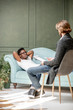 © rh2010 - Young afro ethnicity man having a serious conversation with psychologist lying on the comfortable couch during psychological session in the office. Image with copy sopce