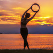 © Sirirat Makprasert - The silhouette of a young woman meditating by yoga at the seafront in the pre-sunset time, this activity makes you feel calm. Healthy body, health and good mental health.