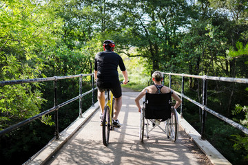 Couple on a exercising together on a bicycle and in a wheelchair