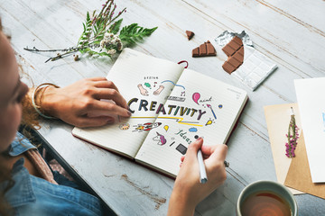 young creative woman drawing in a notebook