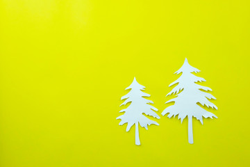 Christmas tree shape of white paper on yellow paper background.