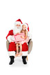 © LIGHTFIELD STUDIOS - santa claus and little child sitting in armchair together and holding gift box isolated on white