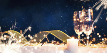 Two Glasses Filled With Garlands With A Candle And A Gold Ribbon In The Snow