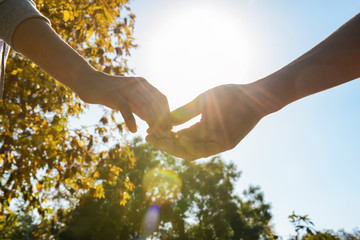 Man and woman touching fingers outdoors