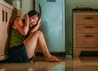 © TheVisualsYouNeed - young scared and helpless Asian Chinese woman horrified suffering domestic violence victim of abuse from drunk alcoholic husband at home kitchen floor crying desperate