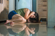 © TheVisualsYouNeed - young scared and helpless Asian Chinese woman horrified suffering domestic violence victim of abuse from drunk alcoholic husband at home kitchen floor crying