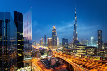 Beautiful aerial view to Dubai downtown city center lights skyline at night, United Arab Emirates. Long exposure light trails effect