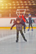 © Daniel CHETRONI - Adorable little boy in winter clothes with protections skating on ice rink