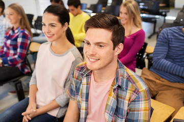 Poster - education, high school and people concept - group of smiling students in lecture hall