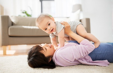 Wall Mural - family and motherhood concept - happy smiling young asian mother with little baby at home