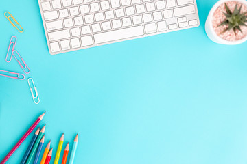 Wall Mural - flat lay photo of office desk with pencil and keyboard ,top view workpace on blue background and cop