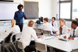 © Monkey Business - Male High School Teacher Standing Next To Interactive Whiteboard And Teaching Lesson To Pupils Wearing Uniform