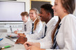 © Monkey Business - Line Of High School Students Wearing Uniform Sitting At Desk In Classroom