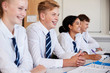 © Monkey Business - Line Of High School Students Wearing Uniform Sitting At Desk In Classroom