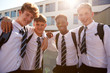 © Monkey Business - Portrait Of Smiling Male High School Students Wearing Uniform Outside College Building