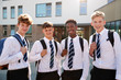 © Monkey Business - Portrait Of Smiling Male High School Students Wearing Uniform Outside College Building
