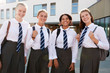 © Monkey Business - Portrait Of Smiling Female High School Students Wearing Uniform Outside College Building