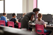© Monkey Business - Female Teacher Supervising Line Of High School Students Working at Screens In Computer Class