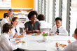 © Monkey Business - Female Teacher With Group Of High School Students Wearing Uniform Sitting Around Table And Eating Lunch In Cafeteria