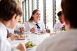 © Monkey Business - Group Of High School Students Wearing Uniform Sitting Around Table And Eating Lunch In Cafeteria