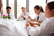 © Monkey Business - Group Of High School Students Wearing Uniform Sitting Around Table And Eating Lunch In Cafeteria
