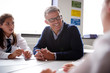 © Monkey Business - Male High School Tutor Sitting At Table With Students Teaching Lesson