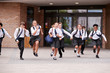 © Monkey Business - Group Of High School Students Wearing Uniform Running Out Of School Buildings Towards Camera At The End Of Class