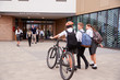 © Monkey Business - Group Of High School Students Wearing Uniform Arriving At School Walking Or Riding Bikes Being Greeted By Teacher
