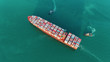 © Pawinee - Aerial top view Tug boats drag container ship to sea port for unload container to container warehouse for logistics import export, shipping or transportation concept.