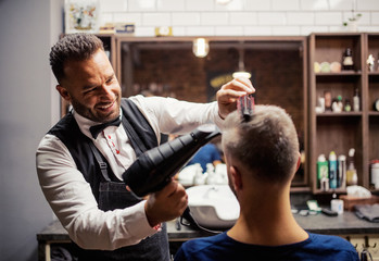 Wall Mural - Hipster man client visiting haidresser and hairstylist in barber shop.