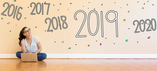 Wall Mural - 2019 New Year with young woman using a laptop computer on floor